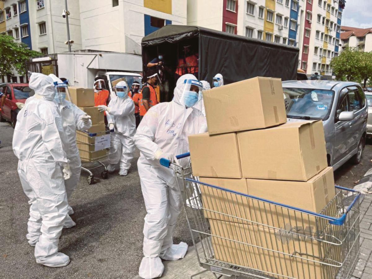 PETUGAS membabitkan pelbagai agensi menggunakan kelengkapan pelindung diri (PPE) ketika menghantar makanan dan barangan keperluan kepada 11,422 penghuni pangsapuri  Perumahan Awam Desa Rejang, Kuala Lumpur.