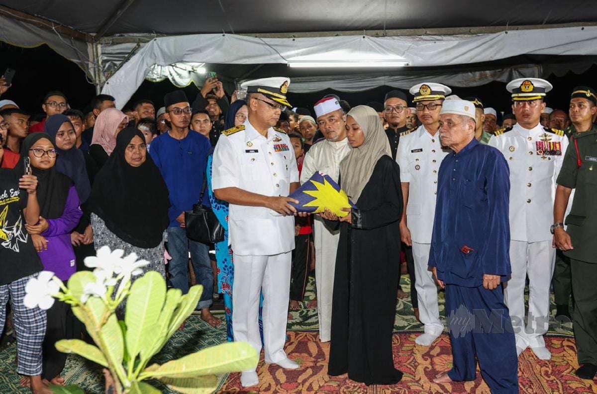 KOMANDER Markas Pangkalan TLDM Lumut, Laksamana Pertama Jamaludin Sairi menyerahkan Ensign TLDM kepada anak sulung Mohd Shahrizan, Nurul Shahfiqah. FOTO Aswadi Alias.