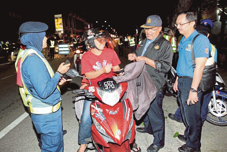 WAN Ahmad Uzir (dua dari kanan) memeriksa kenderaan pada Operasi Hari Raya di Jalan Teluk Sisek.