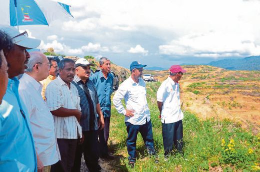 TENGKU Razaleigh (dua dari kiri) melawat ladang sawit peneroka RKT Kesedar Chalil.