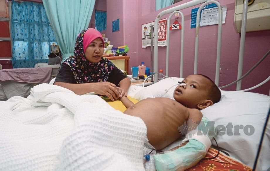NORASANAH melihat anaknya, Muhamad Muazzudin  yang menghidap penyakit kanser di Hospital Pulau Pinang.