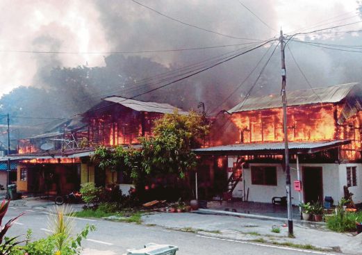 Kebakaran membabitkan tiga rumah di Kampung Baru Sungai Ara, Balik Pulau, semalam. 