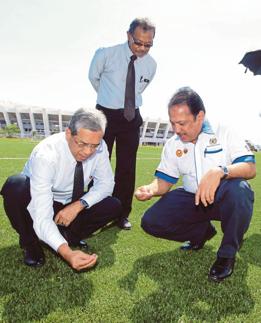 AZHAR (kanan) bersama Pengarah JKR Terengganu, Datuk Shafii Mohamad (kiri) meneliti padang bola sintetik kedua di Terengganu.