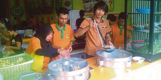 AGUS Sunarno (tengah) dibantu pekerjanya menyiapkan makanan yang dipesan pelanggan.  