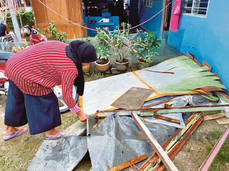 PENDUDUK Kampung Ulu Pulai membersihkan kediaman masing-masing selepas rumah mereka dinaiki air, semalam.