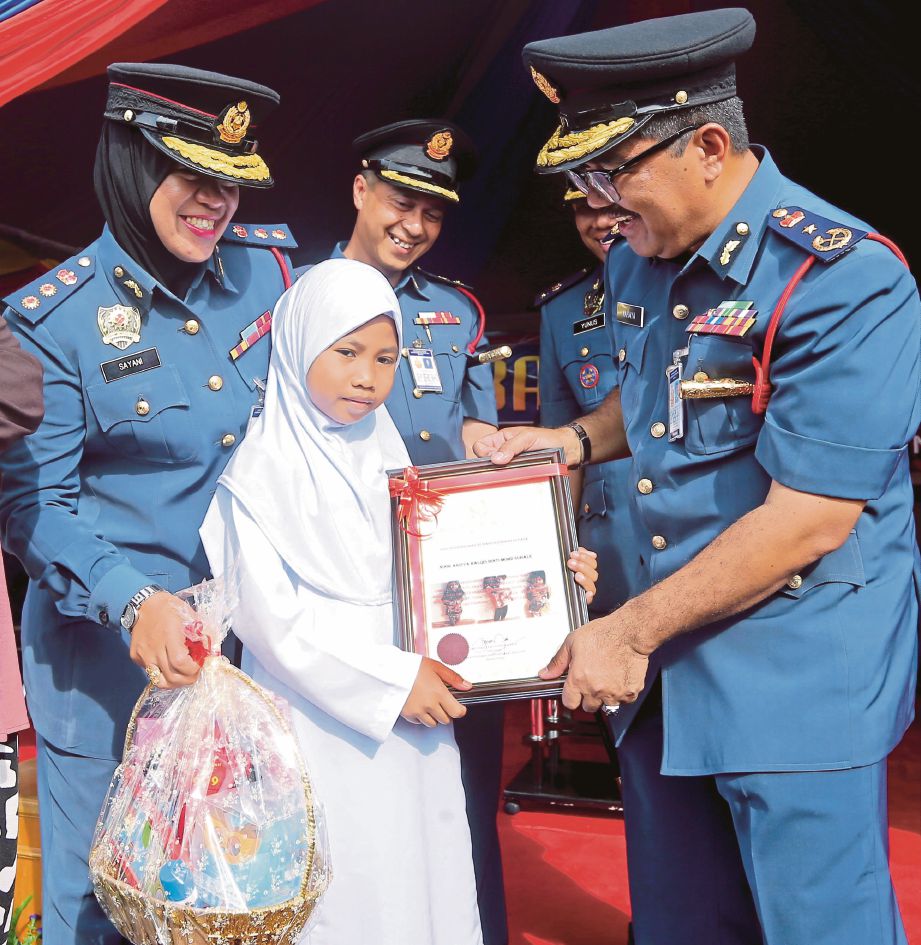   Yahaya   (kanan) menyampaikan sijil penganugerahan wira cilik kepada Noor Arisya  pada    Majlis Perbarisan Tahunan 2018 JBPM Perak di Meru Raya,   semalam.