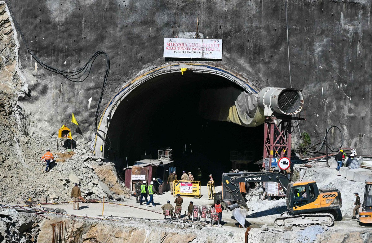 ANGGOTA penyelamat berkumpul di pintu masuk terowong yang runtuh dan menyebabkan 41 pekerja binaan terperangkap sejak dua minggu lalu. FOTO AFP.