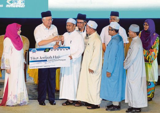 NAJIB  menyampaikan replika tiket jemaah haji kepada penerima  pada  Majlis Perasmian Penutupan Ijtimak Pondok Malaysia 2016, semalam.