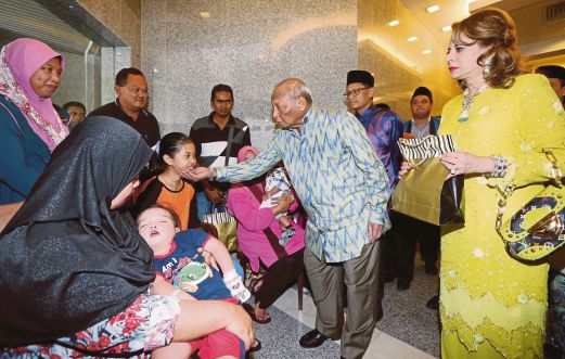SULTAN Ahmad Shah  bersama Sultanah Kalsom  beramah mesra dengan  keluarga kanak-kanak yang menghidap sakit jantung   di IJN, semalam.