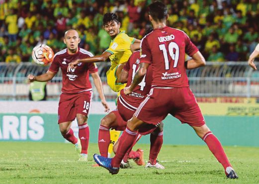 PEMAIN Kedah, Abdul Halim Saari (dua dari kiri) cuba melepasi dua pemain Johor DT.