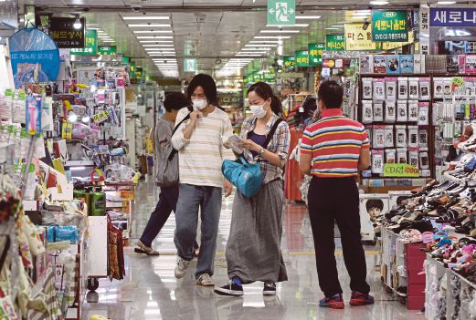 ORANG ramai mengambil langkah berjaga-jaga dengan memakai topeng muka ketika membeli-belah di pasar raya di Seoul.