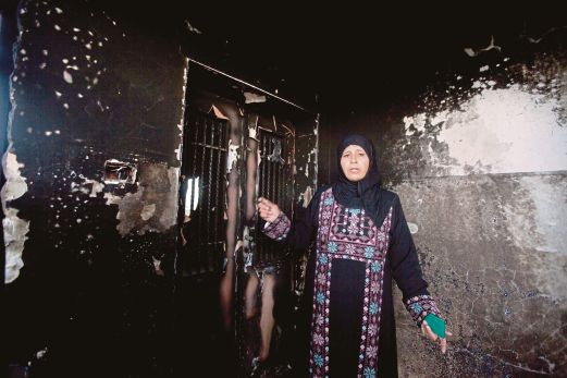 SEORANG wanita menunjukkan kesan kemusnahan rumahnya yang dilontar koktel molotov di Khirbet Abu Falah, Tebing Barat.