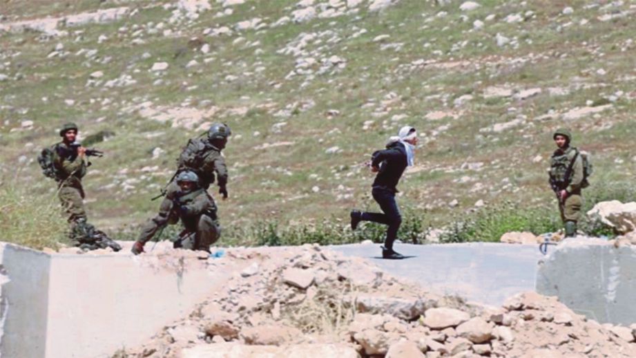 TENTERA Zionis mengejar Hajahjeh yang ditutup mata manakala tangan bergari ke belakang. FOTO Agensi