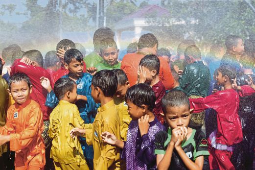 KANAK-KANAK  seronok bermain air sebelum berkhatan   pada Program Sentuhan Kasih di  Kampung Tengah B, Puchong. 