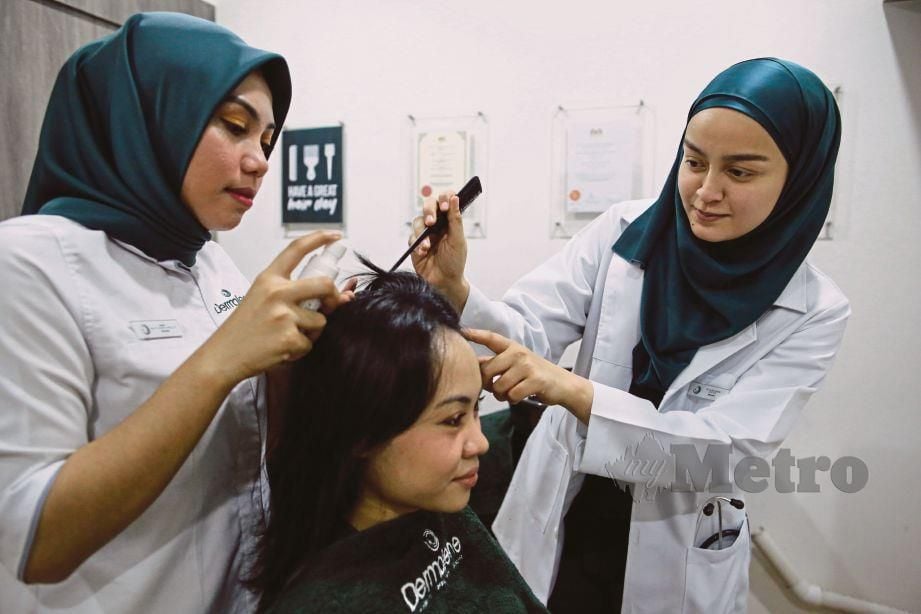 DR Alina menunjukkan rawatan rambut kepada pekerjanya.