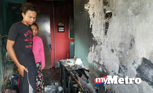 MOHD Alif (kiri) dan isterinya, Amida Anis  melihat barangan dan kelengkapan dapur yang musnah dalam kebakaran.  FOTO Hamzah Osman