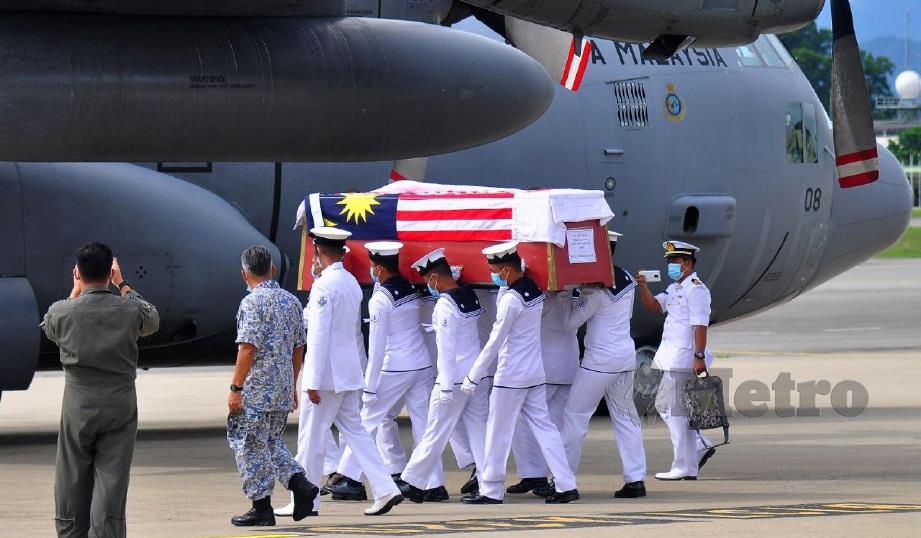 PEGAWAI dan anggota TLDM mengusung keranda jenazah Muhammad Arif sebelum diterbangkan ke Melaka menggunakan pesawat C130H milik TUDM. FOTO Yun Mikail