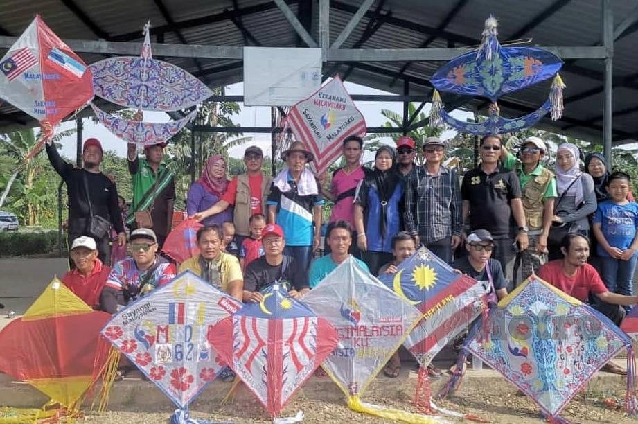 AKMAT (berdiri, dua kiri) bersama sebahagian peserta pertandingan layang-layang di Padang SK Lupak, Kampung Lupak, Beaufort. FOTO Norasikin Daineh