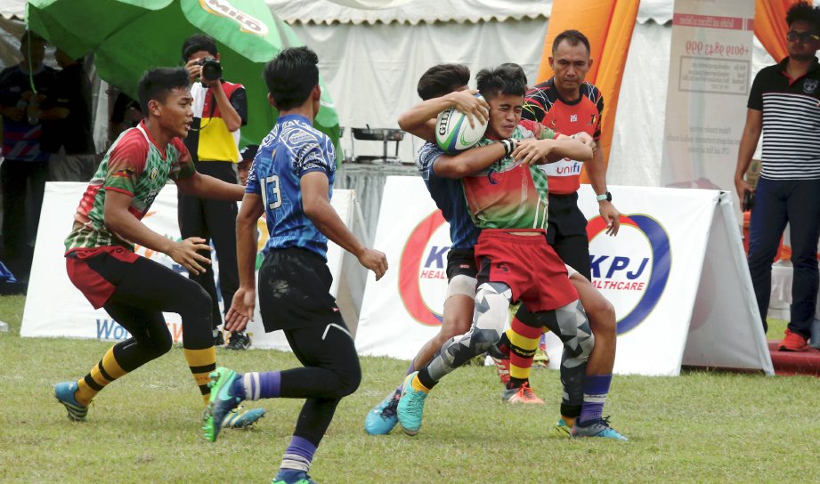 Pemain SHOAW, Ahmad Aiman Jamhee (kanan) mengekang pemain SSTMI pada saingan Kejohanan Ragbi Premier 7's MCKK di Padang Ragbi MCKK. - FOTO L MANIMARAN