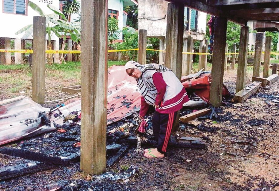WAN Norfatiha menunjukkan kesan terbakar di rumah yang dibina dua bulan lalu.