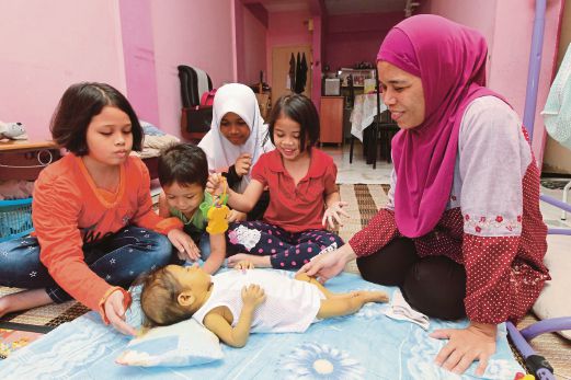 Norhariati bersama anak-anaknya bermain dengan Nurul Syuhada. Gambar kecil, Nurul Syuhada.