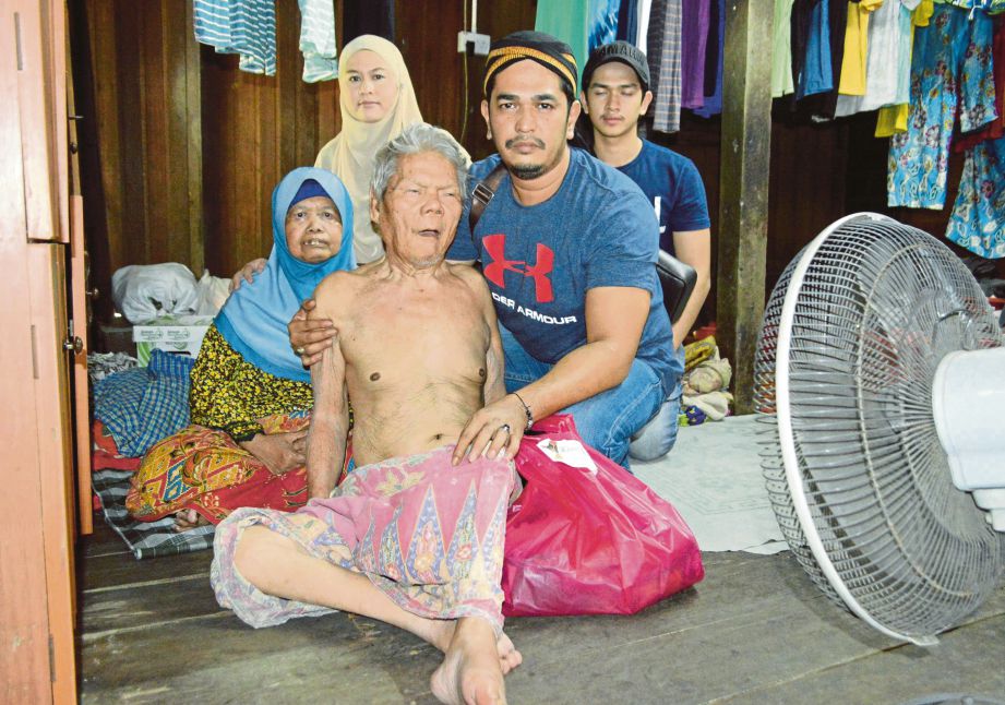 MOHD Shamsul (kanan) menyumbangkan barangan keperluan harian kepada  Abdul Rahim Shabdin @ Shabudin, 78 (tengah) yang mengalami sakit tua bersama isterinya, Salmah Darus , 68 (kiri) di rumah mereka di Permatang Pasir, Permatang Pauh.