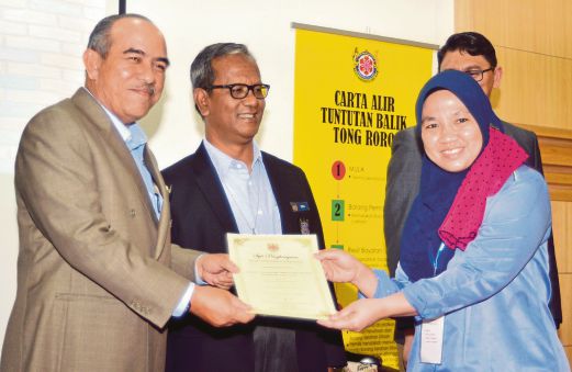AHMAD Zaharin (kiri) menyampaikan sijil penyertaan kepada peserta, Yusnida Asman pada Majlis Penutup Seminar Pengurusan Sampah Sisa Binaan Kawasan Majlis Bandaraya Shah Alam 2015. 