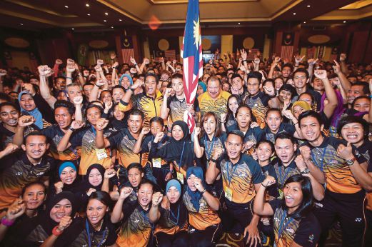 KHAIRY (tengah) bersama atlet yang akan menyertai Sukan SEA 2015 di Singapura pada majlis Penyerahan Jalur Gemilang.