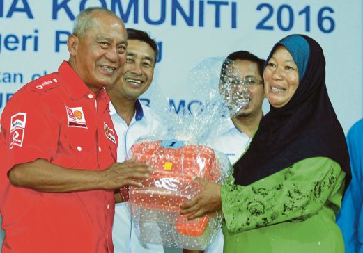  Shahiruddin (kiri) menyampaikan hadiah kepada pemenang di dewan Kampung Kuala Gali, Raub, kelmarin