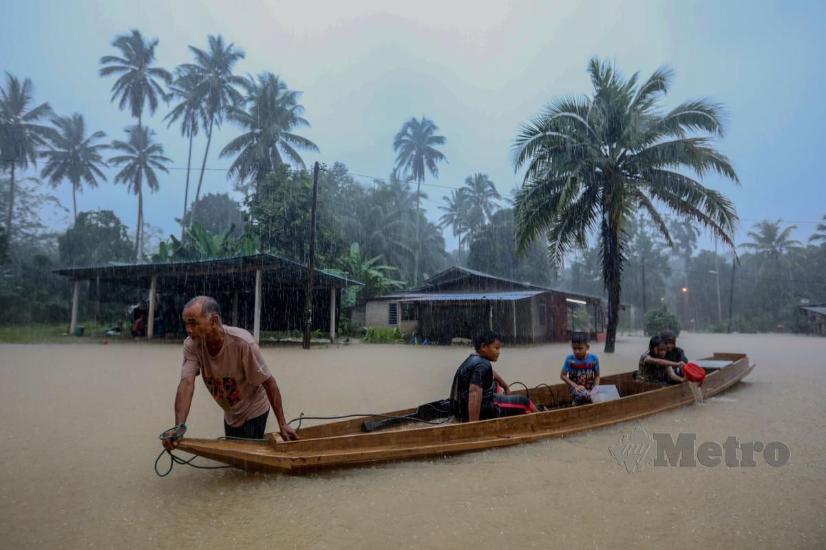 PENDUDUK menaiki sampan meredah banjir selepas hujan lebat sejak semalam di Kampung Shukor. FOTO Ghazali Kori.