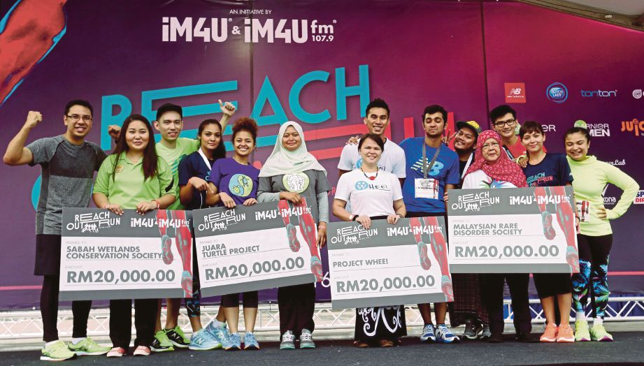  Rudy  (kiri) bersama  wakil penerima dana daripada empat  badan kebajikan  sempena  Reach Out Run anjuran 1M4U di Dataran Putrajaya. 
