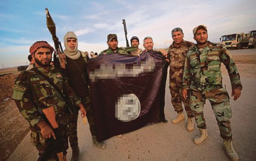  Pejuang Kurdis dan Syiah menunjukkan bendera IS yang diturunkan selepas menawan semula Jalula.