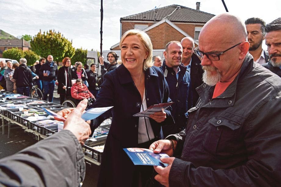 MARINE mengedarkan risalah kempen di sebuah pasar di Bethune, utara Perancis. - AFP 