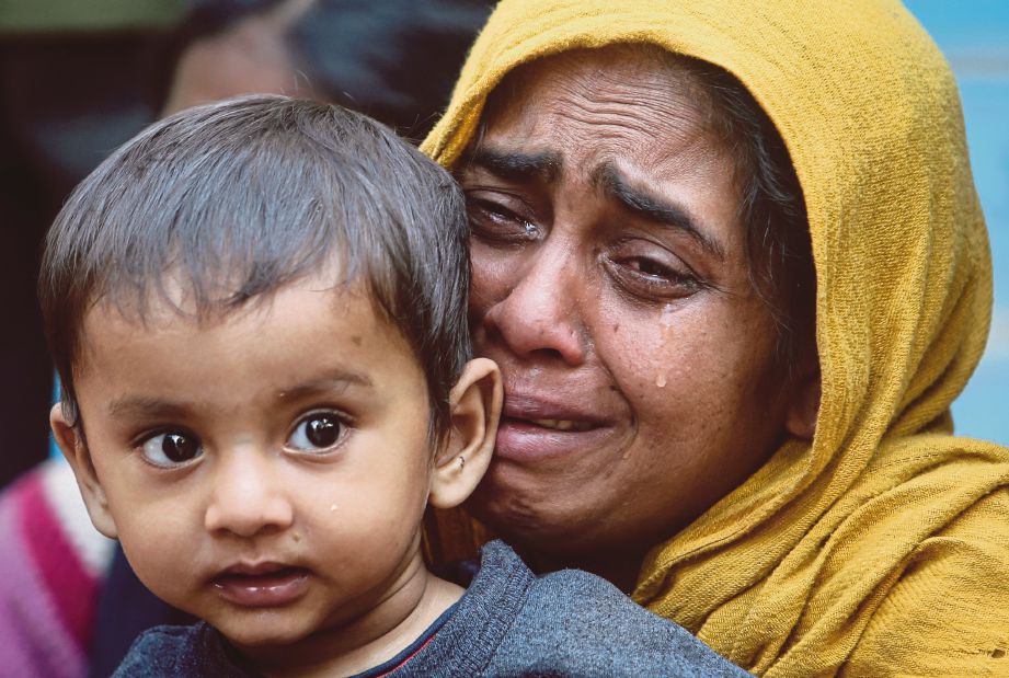 WANITA Rohingya menangis sambil memeluk anak perempuannya selepas ditahan Pasukan Keselamatan Sempadan India di sempadan India-Bangladesh. - Reuters