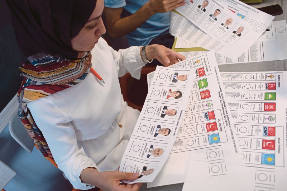 PETUGAS pilihan raya Turki menyediakan kertas undi di sebuah pusat mengundi di Istanbul, semalam. - EPA