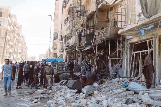 PENDUDUK dan anggota pertahanan memeriksa bangunan yang dibom dalam serangan udara di Aleppo.