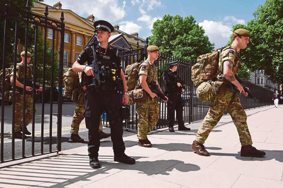 SEBAHAGIAN anggota tentera memasuki bangunan Kementerian Pertahanan berhampiran ibu pejabat polis dan bangunan Parlimen di tengah London semalam selepas mereka dikerah mengawal keselamatan di beberapa kawasan penting di seluruh negara itu.  - AFP 