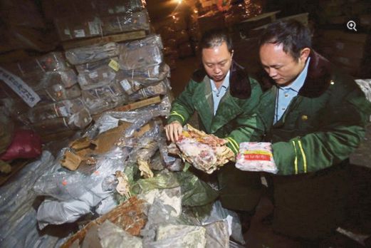 PEGAWAI kastam memeriksa daging reput yang dirampas dalam  serbuan di Hunan baru-baru ini.