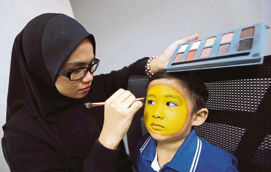 EFFAH membuat solekan lukisan muka ke wajah seorang kanak-kanak.