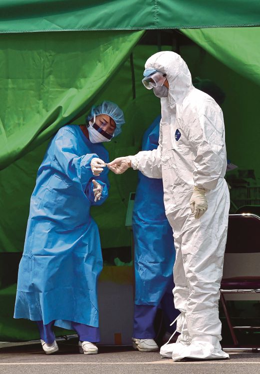 PEKERJA perubatan berpakaian perlindungan lengkap bertugas di klinik yang diasingkan untuk pesakit MERS di Hospital Universiti Konkuk, Seoul.