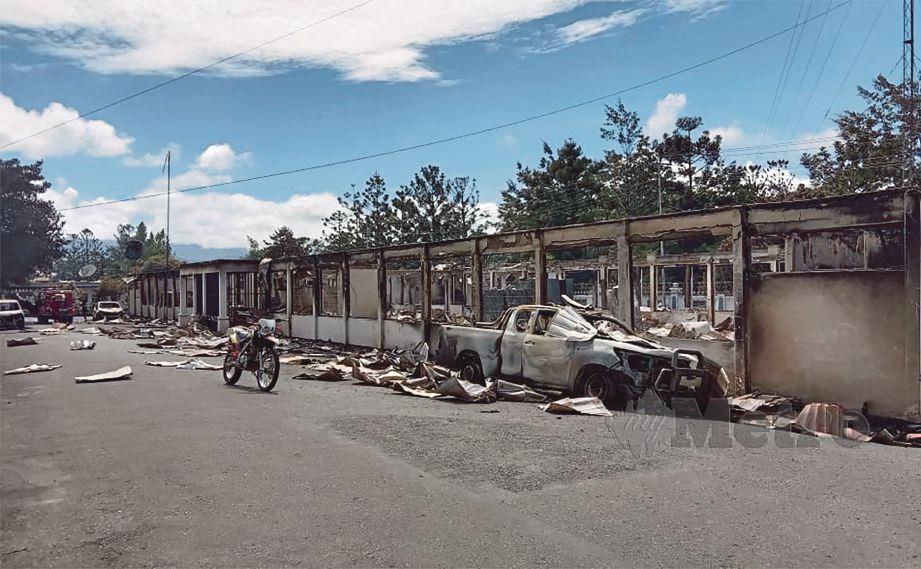 DERETAN kedai dibakar oleh perusuh di Papua. - AFP