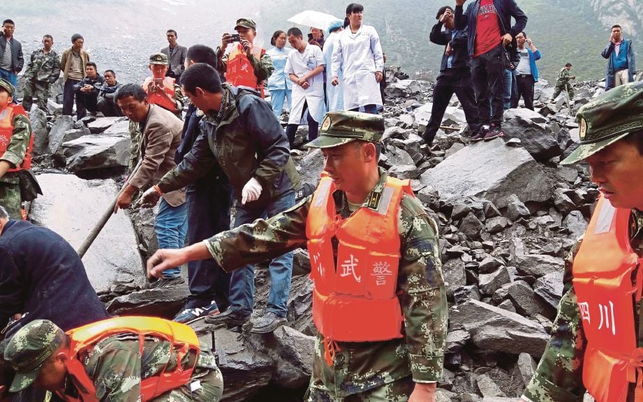 GERAKAN mencari mangsa yang mungkin terselamat di Kampung Xinmo di wilayah Sichuan, semalam.  - AFP