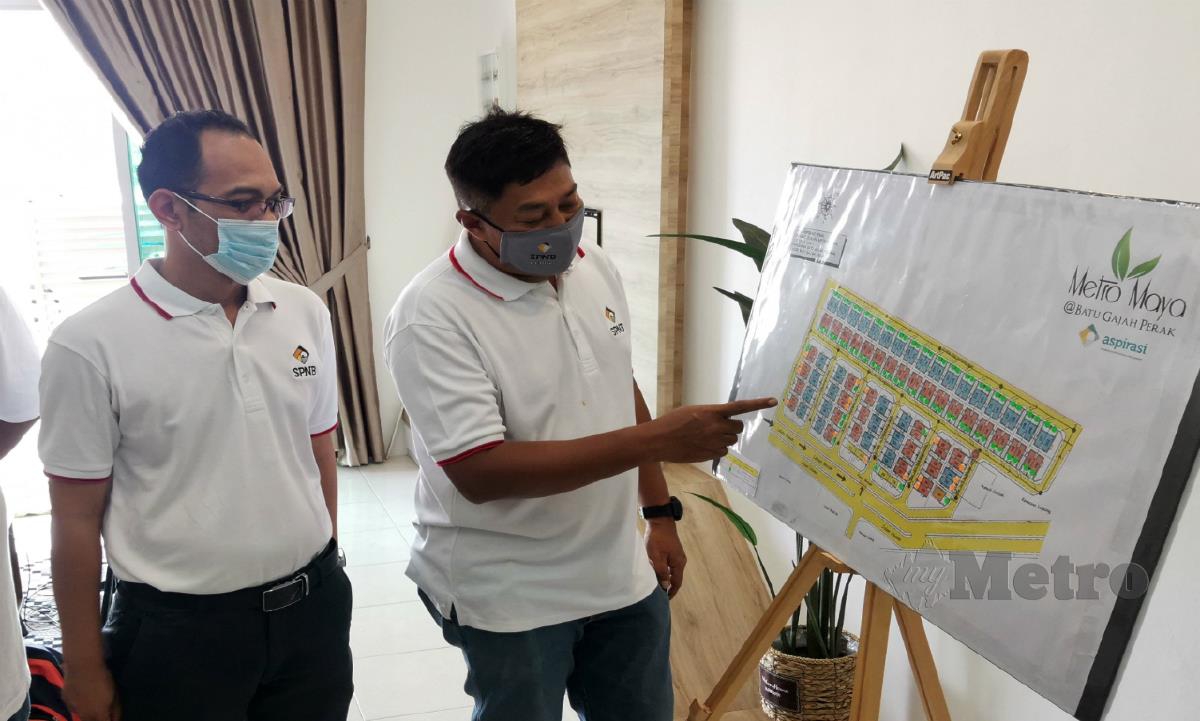 TAJUL Safuan (kanan) menunjukkan peta grafik projek perumahan Metro Maya, hari ini. FOTO Balqis Jazimah Zahari.