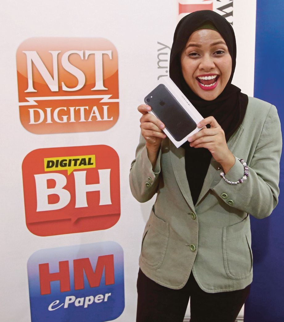 WAN Nur Hazirah   menunjukkan iPhone7 yang dimenanginya. 