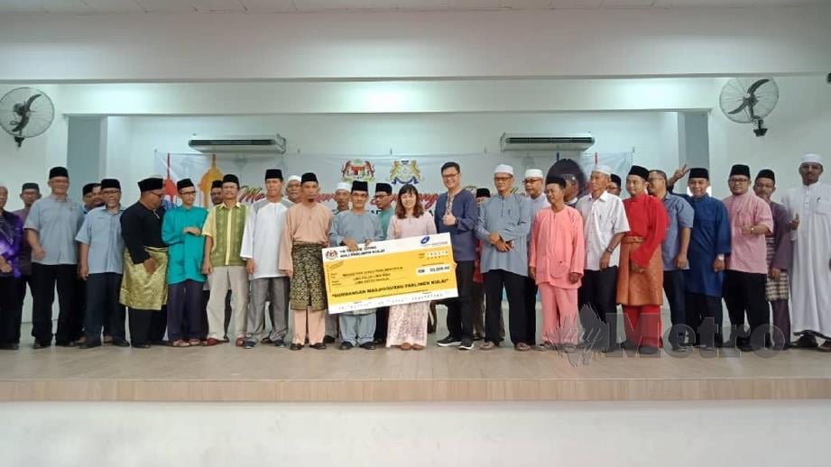 TEO menyampaikan replika cek sumbangan kepada masjid dan surau di  Dewan Taman Putri, Kulai. FOTO ihsan jemaah Masjid Kulai