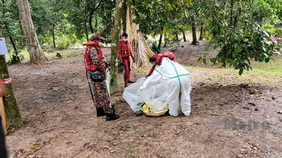 ANGGOTA bomba mengangkat mayat wanita yang ditemui terapung dan tersangkut di dahan pokok dalam sungai. FOTO ihsan Bomba