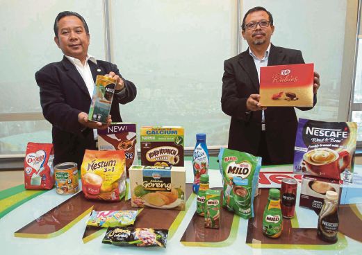  OTHMAN  (kiri) bersama Pengurus Operasi Hal Ehwal Halal Nestle Manufacturing (M) Sdn Bhd, Sarifuddin Mahmud menunjukkan produk di Menara Surian, Mutiara Damansara.