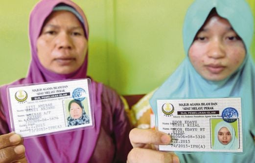 SITI Aminah bersama anaknya, Nor Edayu menunjukkan sijil pemelukan Islam Majlis Agama Islam dan Adat Melayu Perak (MAIPK). 