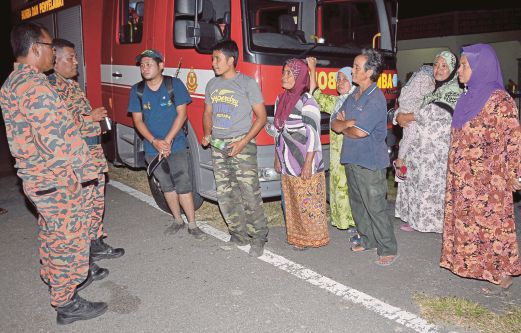 ANGGOTA bomba memberi nasihat kepada Mohd Hafiz (tiga dari kiri) dan Mohd Syaifuldin (empat dari kiri).