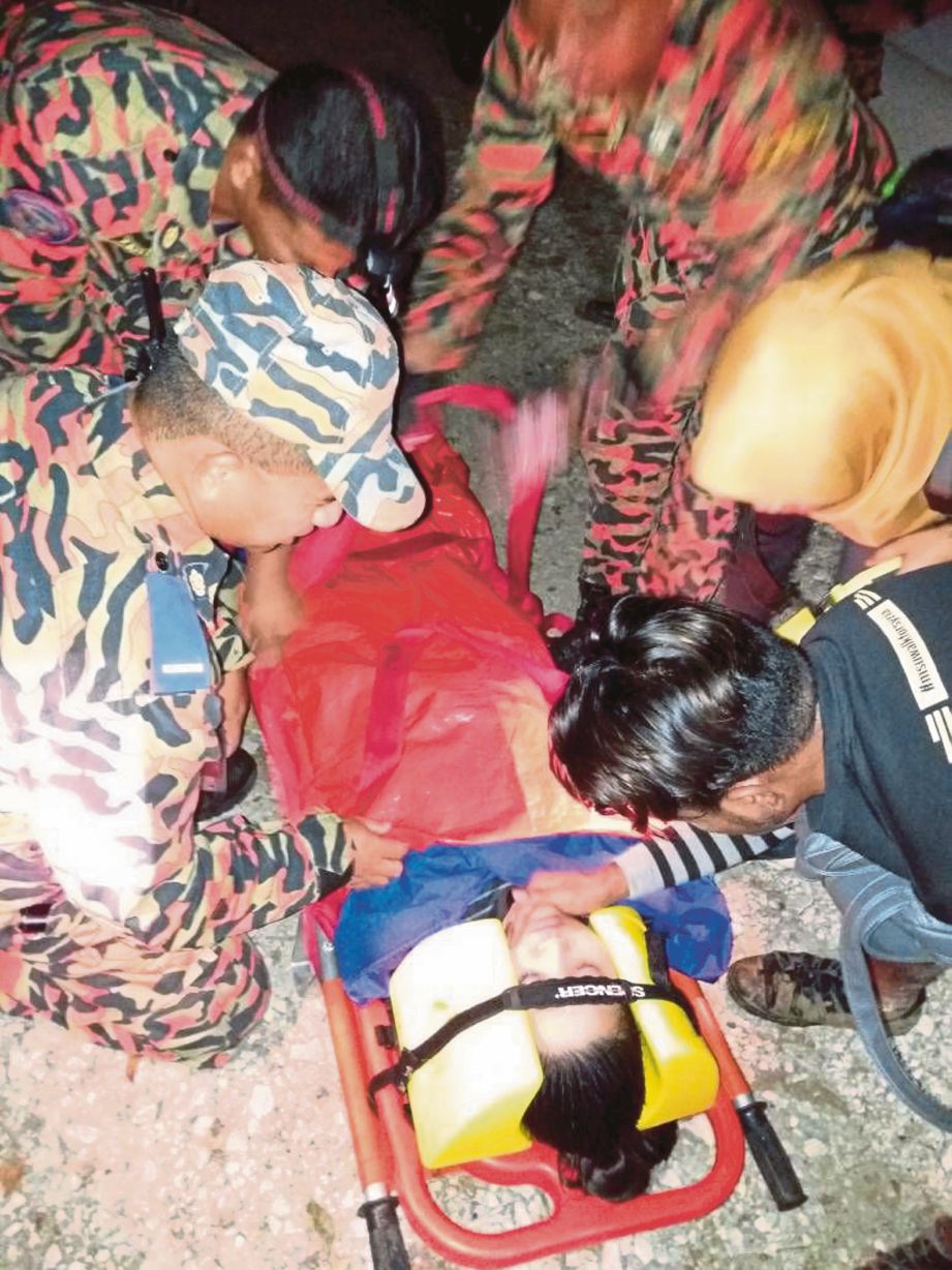ANGGOTA bomba membawa turun guru wanita yang cedera ketika menuruni Bukit Kutu.